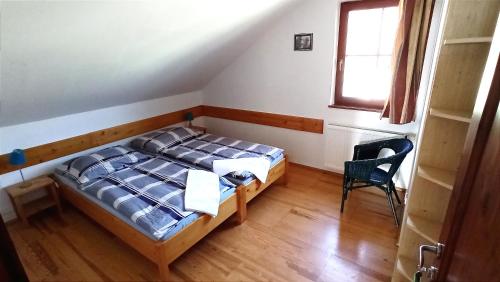 a bedroom with a bed and a chair in it at Penzion Vanda in Velké Pavlovice