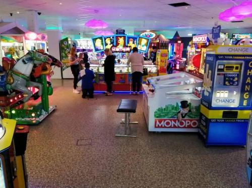 a group of people playing a video game in a arcade at Doc's Cave in Mablethorpe