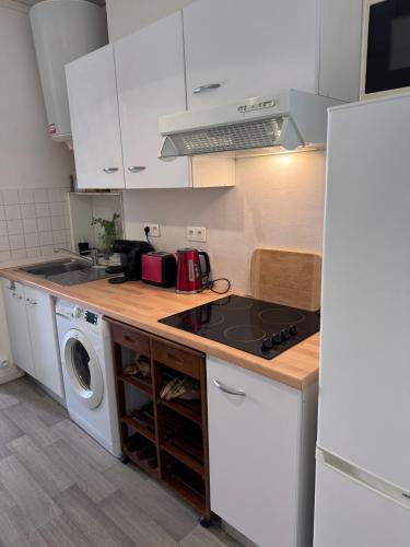 Il comprend une cuisine équipée d'une cuisinière. - un four supérieur à côté d'un lave-linge dans l'établissement Le Farges-Grande Chambre en colocation- 3 minutes Gare St Roch- LaConciergerieByNina, à Montpellier