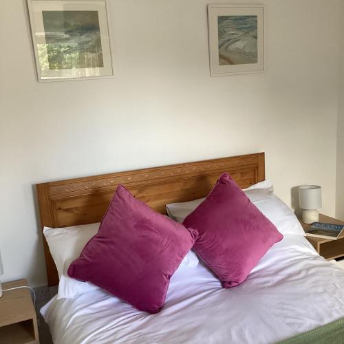 two purple pillows sitting on top of a bed at Cottage in Mid Calder Village near Edinburgh in Mid Calder