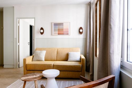 ein Wohnzimmer mit Couch und Tisch in der Unterkunft Babylon Popincourt in Paris