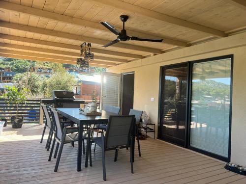 a patio with a table and chairs on a deck at Luxury Seaside Mobile Home DK, Porat Beach in Drage