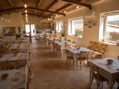 a dining room with tables and chairs and windows at Il poggio degli antichi sapori in Paternopoli