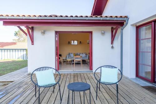 2 chaises et une table sur une terrasse dans l'établissement Villa Typique Arcachon avec plage à pied, à Arcachon