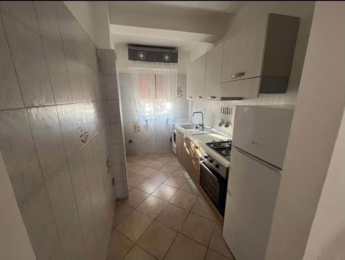 a kitchen with a stove and a white refrigerator at Villa DaMare in Pulsano