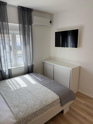 a bedroom with a bed and a tv and a window at Michael's in Zadar