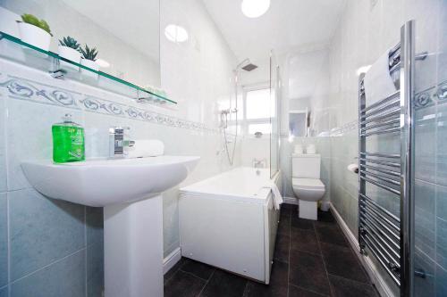 a white bathroom with a sink and a toilet at Belmont Budget Apartment in Stockton-on-Tees