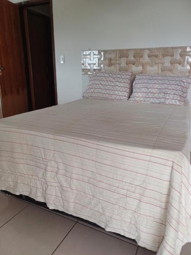 - un lit dans une chambre avec une couverture dans l'établissement Casa de Praia com piscina - Porto de Sauipe, à Porto do Sauipe