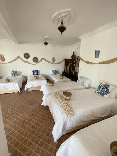 a room with three beds with bowls on them at Villa Ranch Bladna in Tamraght Oufella
