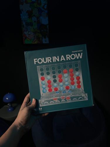 a person holding a book titled four in a row at Modern 3BR Apartment with Game Room in Lekki in Ibeju