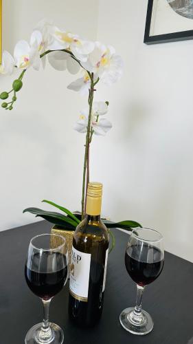 a bottle of wine and two glasses on a table at Cosy and Comfy Deluxe Entire Apartment in London