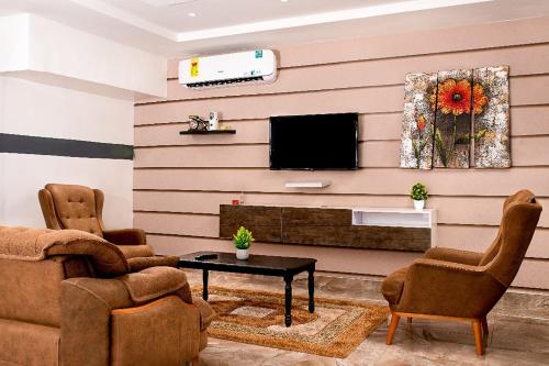 a living room with a flat screen tv on a wall at Lovek Condos in Kumasi