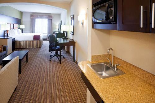 a kitchen with a sink in a hotel room at Holiday Inn Express Hotel & Suites Dallas West, an IHG Hotel in Dallas