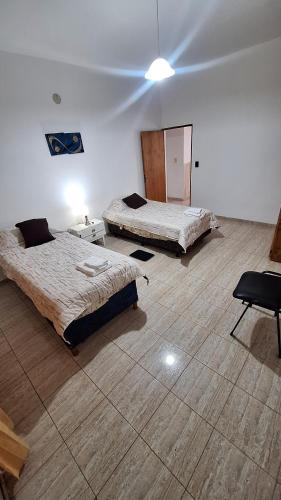 a room with two beds and a chair in it at Apartamentos Marconi in Resistencia