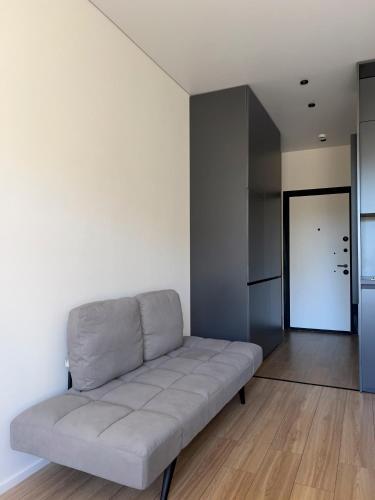 a living room with a white couch in a room at Dreamside Apartment in Chakvi