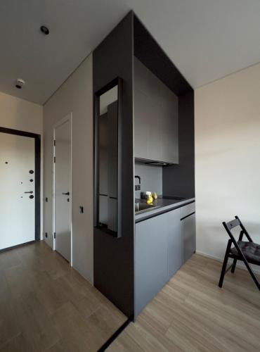 a kitchen with white cabinets and a black wall at Dreamside Apartment in Chakvi