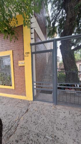 a gate in front of a building with a tree at Apartamentos Marconi in Resistencia