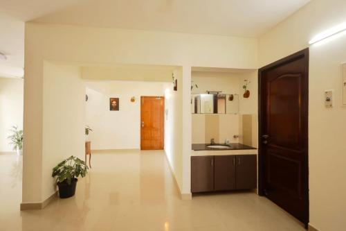 a large kitchen with a sink and a door at Lake View Garden in Trivandrum