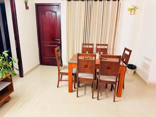 a dining room with a wooden table and chairs at Lake View Garden in Trivandrum