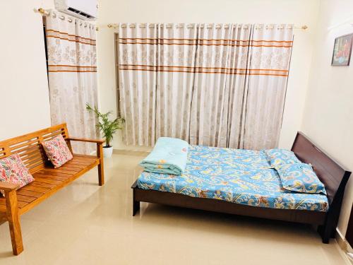 a bedroom with a bed and a bench and a curtain at Lake View Garden in Trivandrum