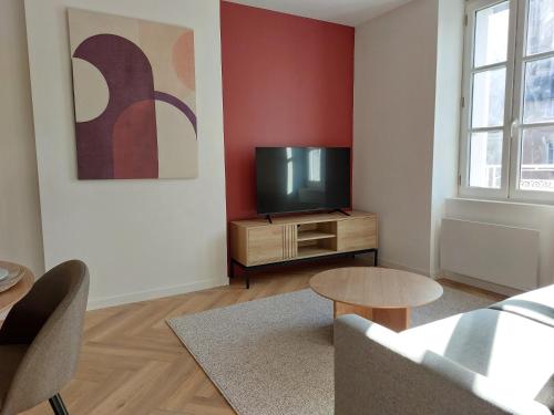 a living room with a tv and a couch at Le Gally 40m2 Cœur de ville avec garage! in Rodez