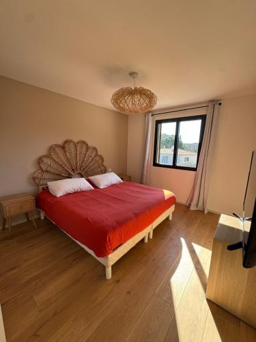 une chambre avec un grand lit avec une couverture rouge dans l'établissement Villa in Roquefort-les-Pins, à Roquefort-les-Pins