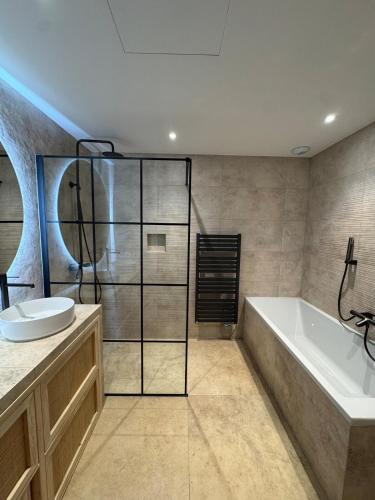 une salle de bain avec une baignoire et un lavabo dans l'établissement Villa in Roquefort-les-Pins, à Roquefort-les-Pins