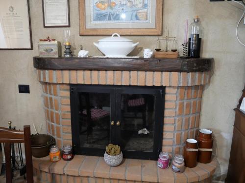 a fireplace with a white bowl on top of it at Il poggio degli antichi sapori in Paternopoli