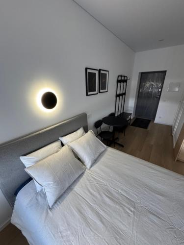 una camera da letto con un grande letto bianco con cuscini bianchi di New Airport Apartment a VNO
