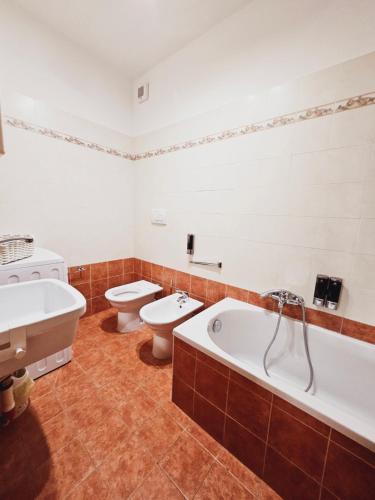 a bathroom with two toilets and a tub and a sink at Residenza Montessori in Avezzano