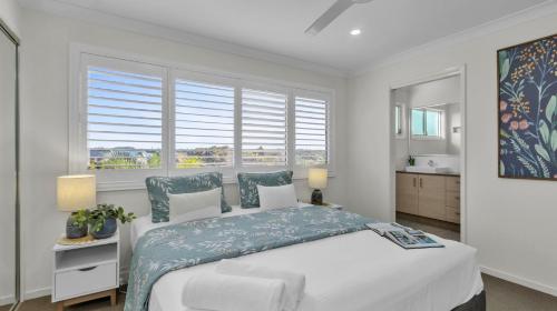 ein weißes Schlafzimmer mit einem großen Bett und einem Fenster in der Unterkunft Sunshine on Saltwater in Kingscliff