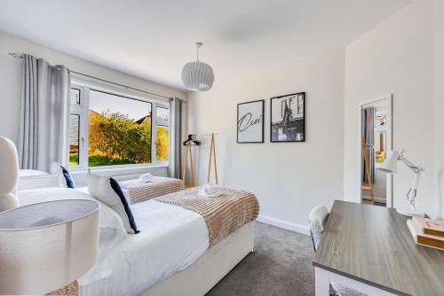 a white bedroom with a bed and a table at Charming Detached Bungalow - Close to Town Centre - Driveway Parking, Self-Check-In, Fast WiFi and Garden by Yoko Property in Northampton