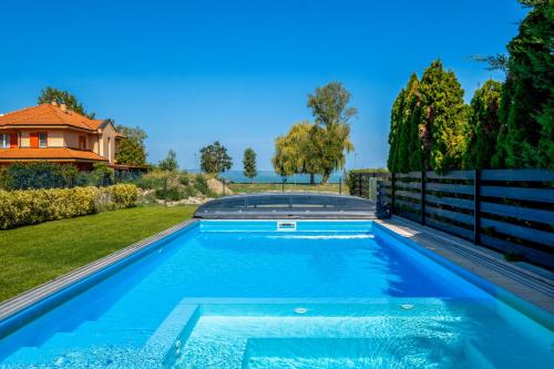 a swimming pool in the backyard of a house at TemOro Apartman Green in Siófok