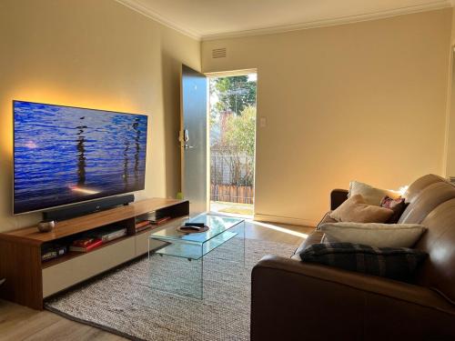 a living room with a couch and a flat screen tv at Happening Harold Street! in Melbourne