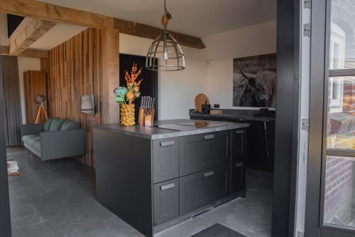 a kitchen with a black island in a room at Huisje over de IJssel in Zwolle