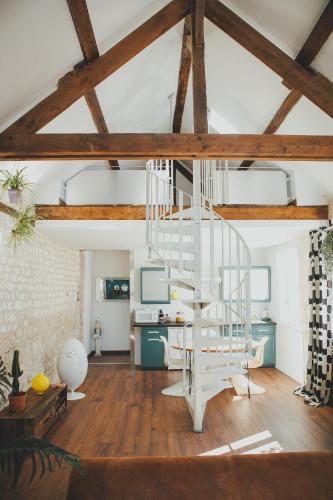 un salon avec un escalier en colimaçon dans un loft dans l'établissement LA LUCIOLE longère 65 m2 climatisée & lumineuse, à Léry