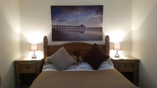 a bedroom with a bed with two lamps and a pier at Farne Lodge in Beadnell