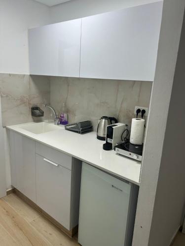a kitchen with white cabinets and a white counter top at Sima Suite 2 in Ashdod