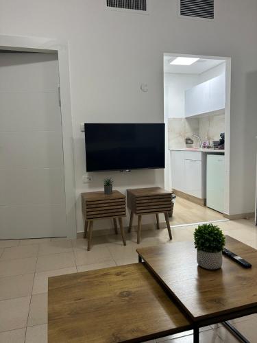a living room with a flat screen tv and a table at Sima Suite 2 in Ashdod