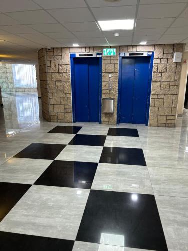 a lobby with two blue doors in a building at Sima Suite 2 in Ashdod
