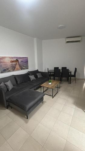 a living room with a couch and tables and chairs at Sima Suite 2 in Ashdod