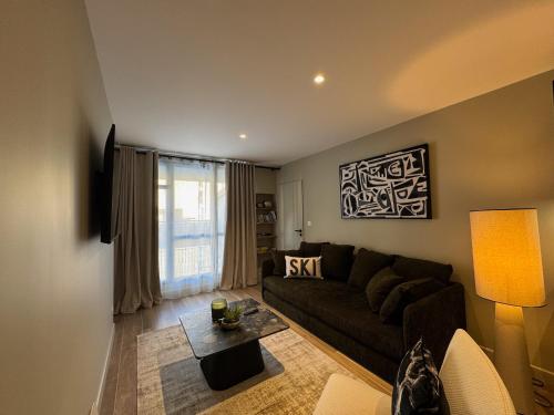 un salon avec un canapé et une table dans l'établissement COSY TERRASSE 6 pers Ax Thermes Centre Parking, à Ax-les-Thermes