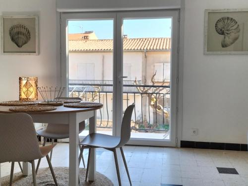 une salle à manger avec une table et des chaises et un balcon dans l'établissement Entre Terre et Mer, à Fleury