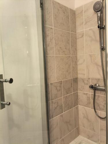 une salle de bain avec une douche avec une porte vitrée dans l'établissement Entre Terre et Mer, à Fleury