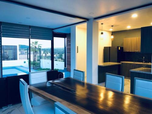 a kitchen and dining room with a large wooden table at Hermosa casa vista al lago in Tequesquitengo