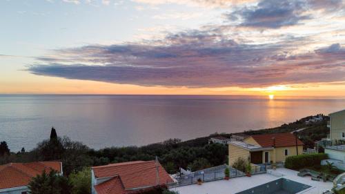 a sunset over the ocean with houses and buildings at Villa Aurora Azure - Luxury Infinity Pool Resort in Katun