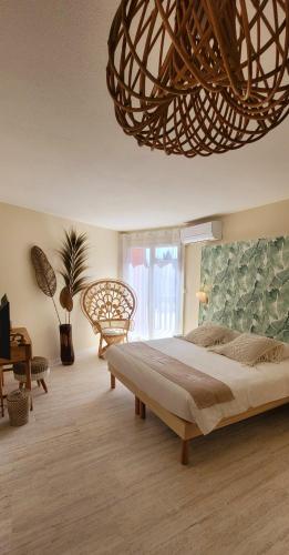 - une chambre avec un grand lit et un grand lustre dans l'établissement Hotel Tennis International, au Cap d'Agde