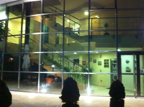 a building with a reflection of a staircase in the window at Hotel El Cruce Moraleda in Moraleda de Zafayona