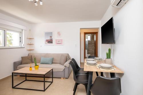 a living room with a couch and a table at Aeolos Loft - 3 min Walk to Beach & Town in Kos