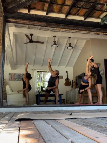 a group of people doing yoga in a room at Morada do Sol Guest House in Búzios